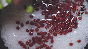 將炒好的食材和大米、紅豆一起放進(jìn)電飯鍋煮。