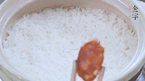 煮開后轉(zhuǎn)小火，當(dāng)米飯出現(xiàn)小孔時，鋪上金字麻辣香腸。