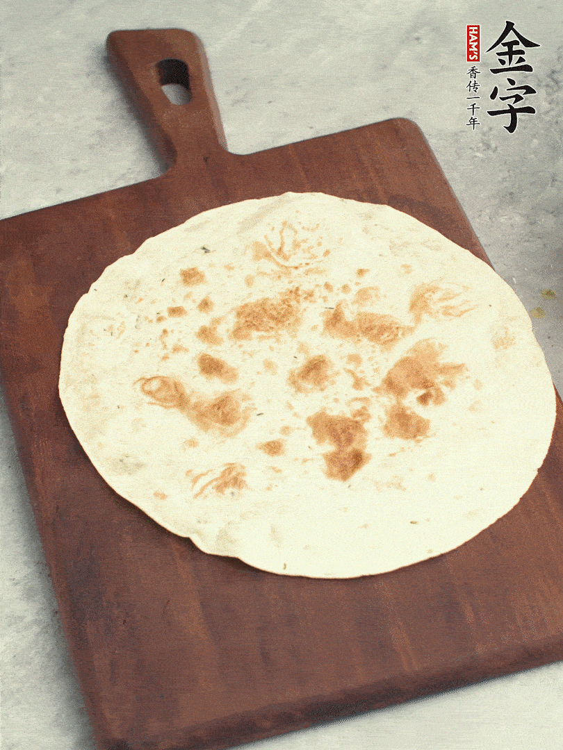 食材依次鋪在卷餅皮上，卷起來(lái)。