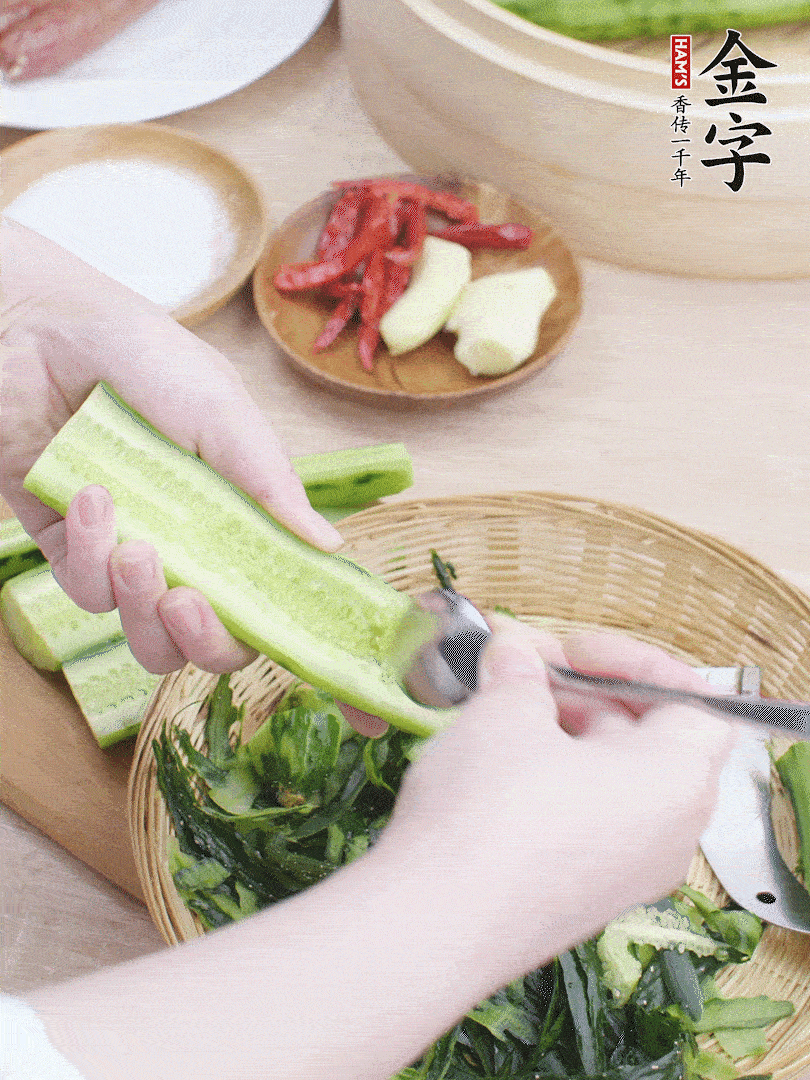 黃瓜削皮，對(duì)半切開，勺子挖去內(nèi)瓤，斜刀切片。青蒜斜刀切段。