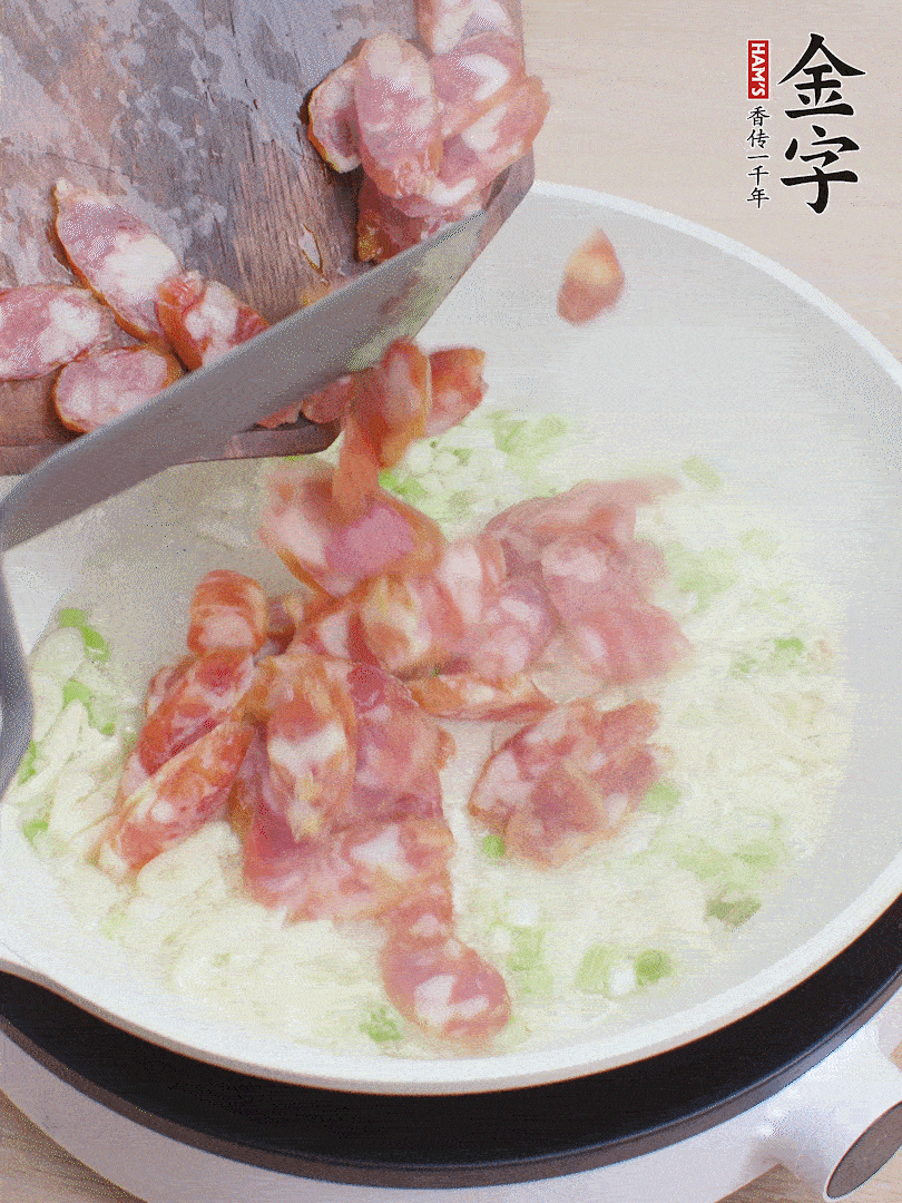 油5成熱，蒜末、蔥白爆香，下香腸炒出香味。