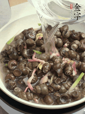 倒處理干凈的螺螄翻炒，加3勺料酒。加清水蓋過螺螄，中火蓋蓋煮5分鐘。