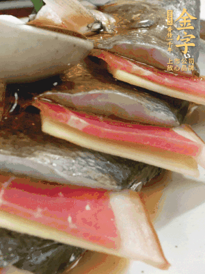 魚肚中塞蔥結(jié)、火腿片，魚身上碼放姜片、火腿片，倒入混合的料汁。