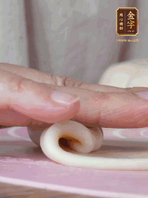 做面劑 油皮按扁，中間包入一個(gè)油酥，邊緣收緊捏死。包好的面劑按扁，用搟面杖搟壓成橢圓形。從底部向上卷成筒狀，用保鮮膜蓋好松弛15分鐘，再把筒狀縱向搟壓成長條狀。再卷一次，松弛20分鐘