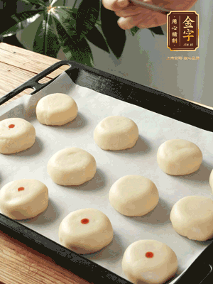收口向下放在案板上，輕輕將月餅坯按扁，用筷子點(diǎn)紅點(diǎn)做裝飾