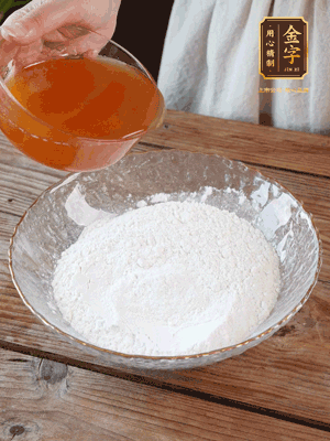 轉(zhuǎn)化糖漿、枧水、花生油攪拌均勻，加入面粉混合，醒發(fā)2小時。捏成23g一個的小球