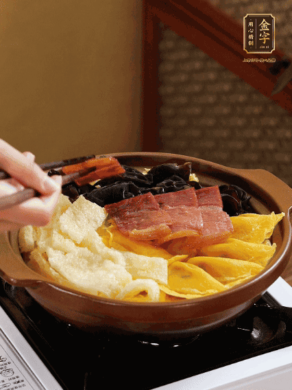 砂鍋底部鋪上娃娃菜，依次擺上肉皮、蛋餃、黑木耳、火腿